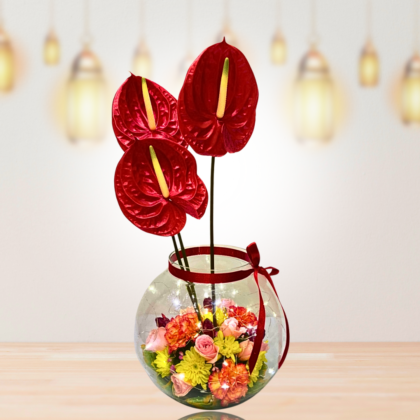 inside round glass vase floral arrangement with fairy lights and 3 red bright anthurium on top best floral arrangement for festive Diwali celebrations