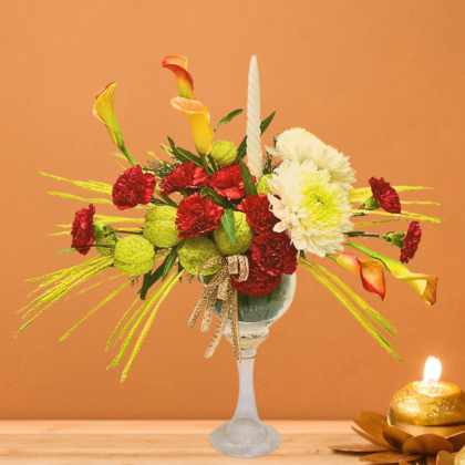 name and description -glass vase floral arrangement with green balloon flowers calla lilies white disbuds red carnations and white candle best floral arrangement for festive Diwali celebrations